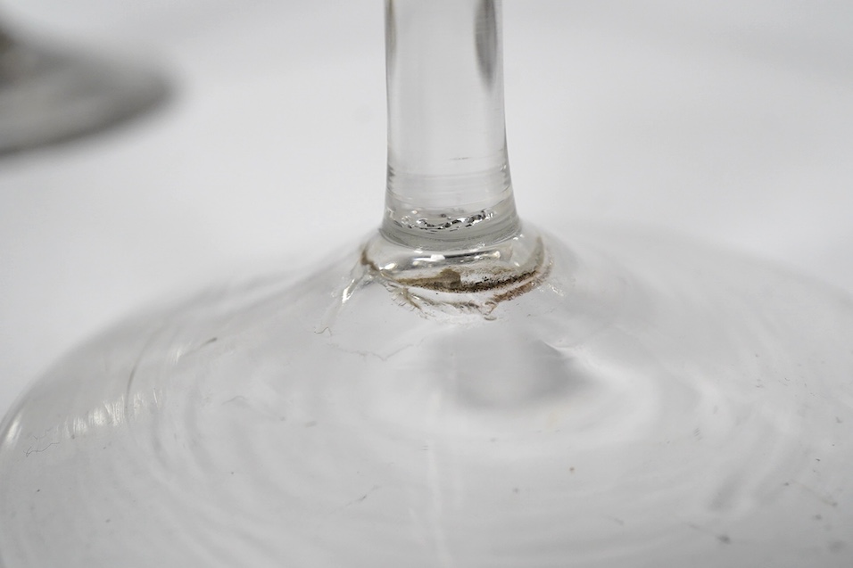 Two drawn trumpet wine glasses, late 18th century and a balustroid gin glass, c.1740, 12.4cm - 18.7cm high (3). Condition - the slender trumpet wine glass has some glue residue to the pontil mark but there is no evidence